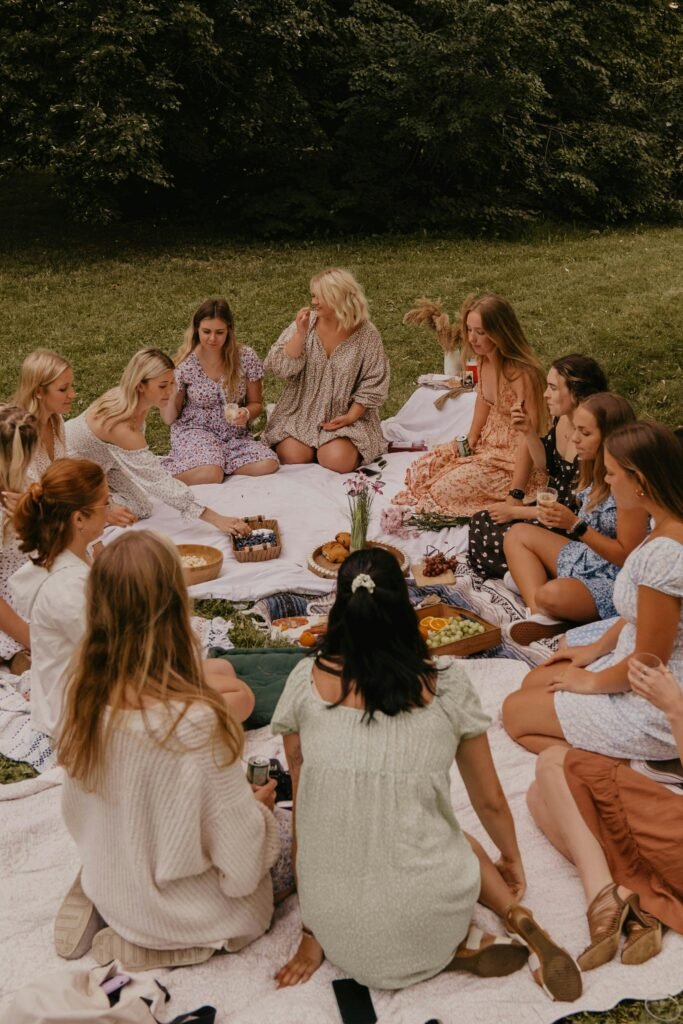 Group of women having a picnic in a park, enjoying food and leisure on a sunny day.